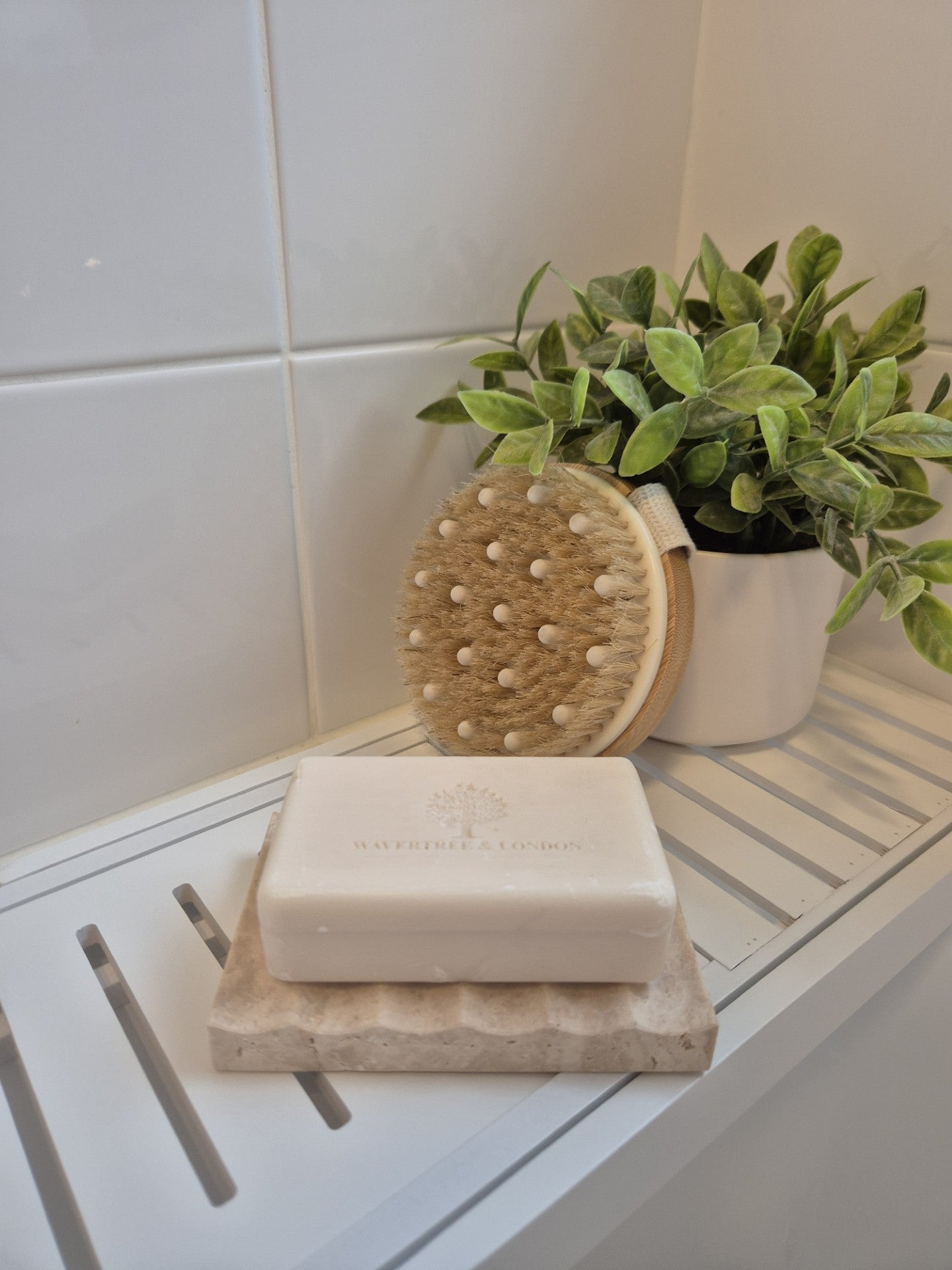 Travertine soap holder holding a bar soap