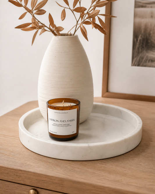 White marble bowl on display with a candle and a white vase